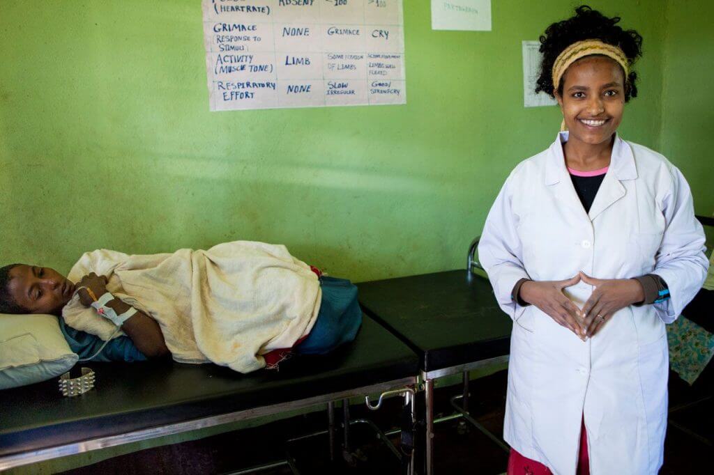 Midwife attending a woman in labor in rural clinic