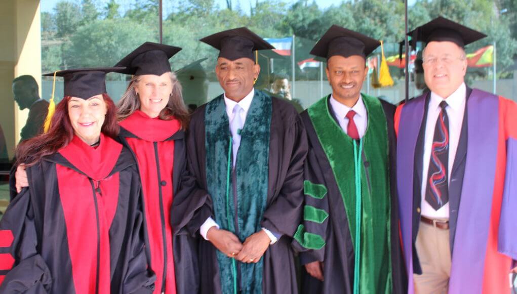 Graduates and mentors in graduation robes